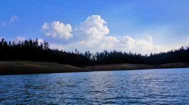 Pykara Gölü, Ooty, Tamilnadu 'nun güzel manzarası. Gökyüzünün muhteşem manzarası, su ve tekne yolculuğundan görülebilen yeşil çalılar. Güney Hindistan 'daki en iyi balayı yeri..
