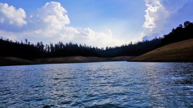 Pykara Gölü, Ooty, Tamilnadu 'nun güzel manzarası. Gökyüzünün muhteşem manzarası, su ve tekne yolculuğundan görülebilen yeşil çalılar. Güney Hindistan 'daki en iyi balayı yeri..