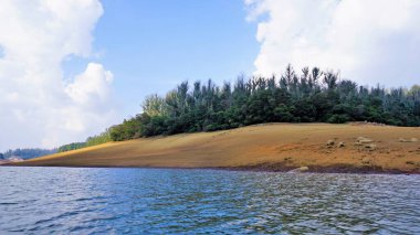 Pykara Gölü, Ooty, Tamilnadu 'nun güzel manzarası. Gökyüzünün muhteşem manzarası, su ve tekne yolculuğundan görülebilen yeşil çalılar. Güney Hindistan 'daki en iyi balayı yeri..