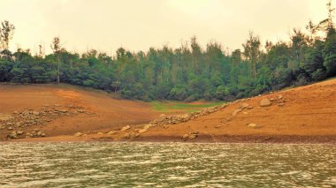Günbatımında Pykara Gölü, Ooty, Tamilnadu 'nun güzel manzarası. Gökyüzü manzarası, su, gün batımı ve tekne yolculuğundan görülebilen yeşil çalılar. Güney Hindistan 'daki en iyi balayı yeri..