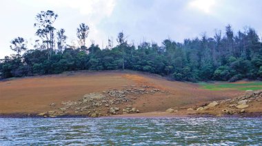 Günbatımında Pykara Gölü, Ooty, Tamilnadu 'nun güzel manzarası. Gökyüzü manzarası, su, gün batımı ve tekne yolculuğundan görülebilen yeşil çalılar. Güney Hindistan 'daki en iyi balayı yeri..