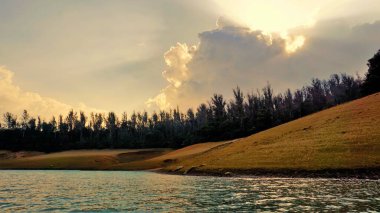 Günbatımında Pykara Gölü, Ooty, Tamilnadu 'nun güzel manzarası. Gökyüzü manzarası, su, gün batımı ve tekne yolculuğundan görülebilen yeşil çalılar. Güney Hindistan 'daki en iyi balayı yeri..