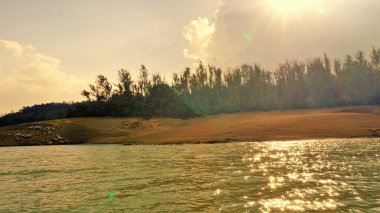 Günbatımında Pykara Gölü, Ooty, Tamilnadu 'nun güzel manzarası. Gökyüzü manzarası, su, gün batımı ve tekne yolculuğundan görülebilen yeşil çalılar. Güney Hindistan 'daki en iyi balayı yeri..