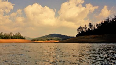Günbatımında Pykara Gölü, Ooty, Tamilnadu 'nun güzel manzarası. Gökyüzü manzarası, su, gün batımı ve tekne yolculuğundan görülebilen yeşil çalılar. Güney Hindistan 'daki en iyi balayı yeri..