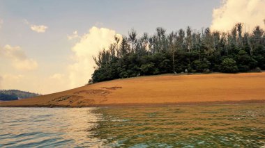 Günbatımında Pykara Gölü, Ooty, Tamilnadu 'nun güzel manzarası. Gökyüzü manzarası, su, gün batımı ve tekne yolculuğundan görülebilen yeşil çalılar. Güney Hindistan 'daki en iyi balayı yeri..