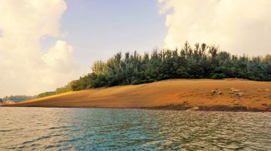 Günbatımında Pykara Gölü, Ooty, Tamilnadu 'nun güzel manzarası. Gökyüzü manzarası, su, gün batımı ve tekne yolculuğundan görülebilen yeşil çalılar. Güney Hindistan 'daki en iyi balayı yeri..