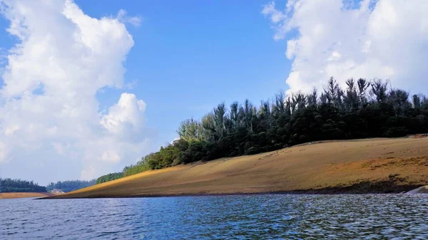 Pykara Gölü, Ooty, Tamilnadu 'nun güzel manzarası. Gökyüzünün muhteşem manzarası, su ve tekne yolculuğundan görülebilen yeşil çalılar. Güney Hindistan 'daki en iyi balayı yeri..