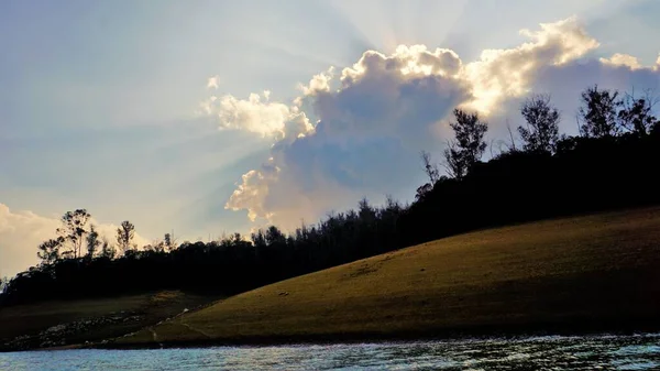 Günbatımında Pykara Gölü, Ooty, Tamilnadu 'nun güzel manzarası. Gökyüzü manzarası, su, gün batımı ve tekne yolculuğundan görülebilen yeşil çalılar. Güney Hindistan 'daki en iyi balayı yeri..