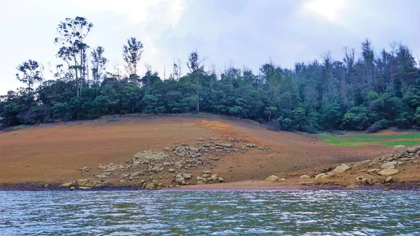 Günbatımında Pykara Gölü, Ooty, Tamilnadu 'nun güzel manzarası. Gökyüzü manzarası, su, gün batımı ve tekne yolculuğundan görülebilen yeşil çalılar. Güney Hindistan 'daki en iyi balayı yeri..