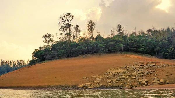 Günbatımında Pykara Gölü, Ooty, Tamilnadu 'nun güzel manzarası. Gökyüzü manzarası, su, gün batımı ve tekne yolculuğundan görülebilen yeşil çalılar. Güney Hindistan 'daki en iyi balayı yeri..