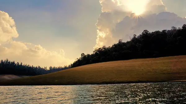 Günbatımında Pykara Gölü, Ooty, Tamilnadu 'nun güzel manzarası. Gökyüzü manzarası, su, gün batımı ve tekne yolculuğundan görülebilen yeşil çalılar. Güney Hindistan 'daki en iyi balayı yeri..