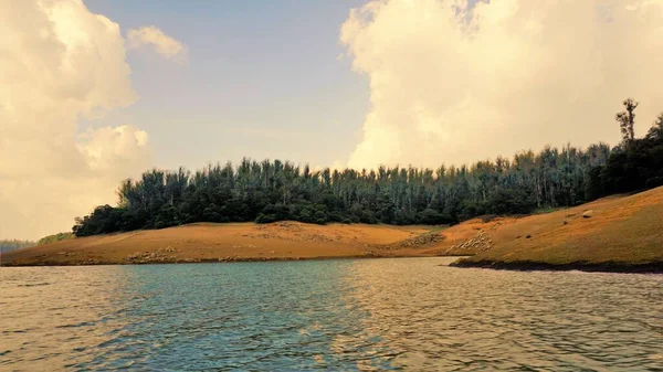Günbatımında Pykara Gölü, Ooty, Tamilnadu 'nun güzel manzarası. Gökyüzü manzarası, su, gün batımı ve tekne yolculuğundan görülebilen yeşil çalılar. Güney Hindistan 'daki en iyi balayı yeri..
