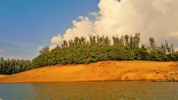 Günbatımında Pykara Gölü, Ooty, Tamilnadu 'nun güzel manzarası. Gökyüzü manzarası, su, gün batımı ve tekne yolculuğundan görülebilen yeşil çalılar. Güney Hindistan 'daki en iyi balayı yeri..