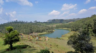 Ooty, Tamilnadu, Hindistan-30 Nisan 2022: Pykara Şelaleleri 'nde akan güzel nehir manzarasının tadını çıkaran turistler, Ooty. Güney Asya 'nın en iyi balayı turistik beldesi..