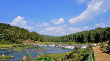 Ooty, Tamilnadu, Hindistan-30 Nisan 2022: Pykara Şelaleleri 'nde akan güzel nehir manzarasının tadını çıkaran turistler, Ooty. Güney Asya 'nın en iyi balayı turistik beldesi..