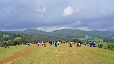 Ooty, Tamilnadu, Hindistan-Haziran 04-22: Wenlock Downs 9. Mil Atış Noktası olarak bilinen yerde güzel yeşil çimlerin keyfini çıkaran turistler.
