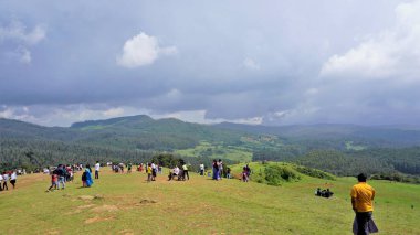 Ooty, Tamilnadu, Hindistan-Haziran 04-22: Wenlock Downs 9. Mil Atış Noktası olarak bilinen yerde güzel yeşil çimlerin keyfini çıkaran turistler.