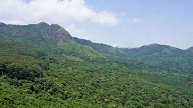 Ooty 'nin güzel manzaraları. Kayaların üzerinde yeşil örtülü dağlar ve açık bulutlu gökyüzü. Aile zamanı ve rahatlama için en iyi yer..