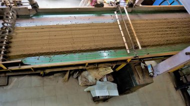 Ooty, Tamilnadu, Hindistan-30 Nisan 2022: Ham madde yapraklarından bitmiş çay gücüne kadar çay yapraklarının makinelerle işlenmesi. Yapraklar çeşitli aşamalarda paketlenmiş çaya dönüştürülür..