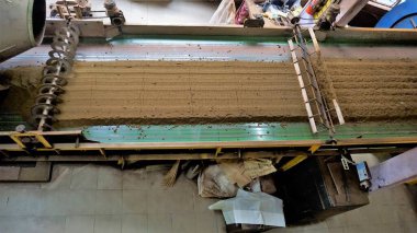 Ooty, Tamilnadu, Hindistan-30 Nisan 2022: Ham madde yapraklarından bitmiş çay gücüne kadar çay yapraklarının makinelerle işlenmesi. Yapraklar çeşitli aşamalarda paketlenmiş çaya dönüştürülür..