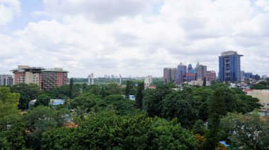 Bangalore,Karnataka,India-June 19 2022: View of Bangalore cityscape from terrace of Chancery Pavilion Hotel. Stadium and skyscrapers such as Prestige UB City Concorde Block visible through green cover.