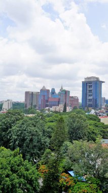 Bangalore,Karnataka,India-June 19 2022: View of Bangalore cityscape from terrace of Chancery Pavilion Hotel. Stadium and skyscrapers such as Prestige UB City Concorde Block visible through green cover.