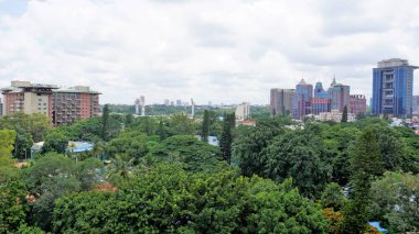 Bangalore,Karnataka,India-June 19 2022: View of Bangalore cityscape from terrace of Chancery Pavilion Hotel. Stadium and skyscrapers such as Prestige UB City Concorde Block visible through green cover.
