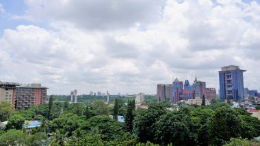 Bangalore,Karnataka,India-June 19 2022: View of Bangalore cityscape from terrace of Chancery Pavilion Hotel. Stadium and skyscrapers such as Prestige UB City Concorde Block visible through green cover.