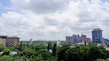 Bangalore,Karnataka,India-June 19 2022: View of Bangalore cityscape from terrace of Chancery Pavilion Hotel. Stadium and skyscrapers such as Prestige UB City Concorde Block visible through green cover.