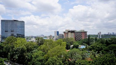 Bangalore,Karnataka,India-June 19 2022: View of Bangalore cityscape from terrace of Chancery Pavilion Hotel. Stadium and skyscrapers such as Prestige UB City Concorde Block visible through green cover.