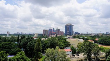 Bangalore,Karnataka,India-June 19 2022: View of Bangalore cityscape from terrace of Chancery Pavilion Hotel. Stadium and skyscrapers such as Prestige UB City Concorde Block visible through green cover.