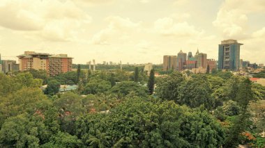 Bangalore,Karnataka,India-June 19 2022: View of Bangalore cityscape from terrace of Chancery Pavilion Hotel. Stadium and skyscrapers such as Prestige UB City Concorde Block visible through green cover.