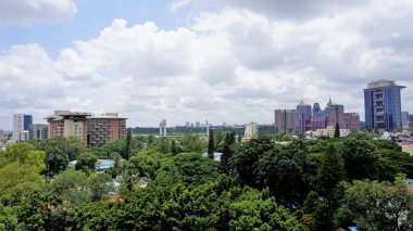 Bangalore,Karnataka,India-June 19 2022: View of Bangalore cityscape from terrace of Chancery Pavilion Hotel. Stadium and skyscrapers such as Prestige UB City Concorde Block visible through green cover.