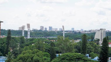 Bangalore,Karnataka,India-June 19 2022: View of Bangalore cityscape from terrace of Chancery Pavilion Hotel. Stadium and skyscrapers such as Prestige UB City Concorde Block visible through green cover.