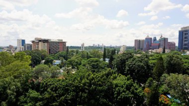 Bangalore,Karnataka,India-June 19 2022: View of Bangalore cityscape from terrace of Chancery Pavilion Hotel. Stadium and skyscrapers such as Prestige UB City Concorde Block visible through green cover.