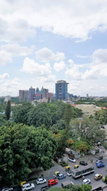 Bangalore,Karnataka,India-June 19 2022: View of Bangalore cityscape from terrace of Chancery Pavilion Hotel with busy road of Bangalore city. Stadium and skyscrapers such as Prestige UB City Concorde Block visible through green cover along with city 