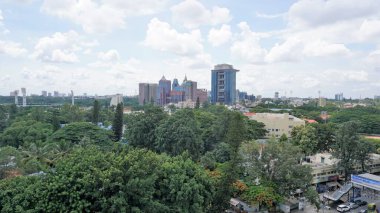 Bangalore,Karnataka,India-June 19 2022: View of Bangalore cityscape from terrace of Chancery Pavilion Hotel with busy road of Bangalore city. Stadium and skyscrapers such as Prestige UB City Concorde Block visible through green cover along with city 