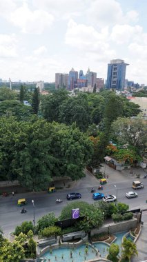 Bangalore,Karnataka,India-June 19 2022: View of Bangalore cityscape from terrace of Chancery Pavilion Hotel with busy road of Bangalore city. Stadium and skyscrapers such as Prestige UB City Concorde Block visible through green cover along with city 