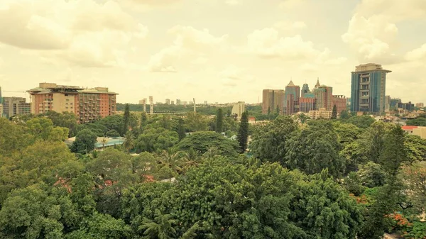 Bangalore,Karnataka,India-June 19 2022: View of Bangalore cityscape from terrace of Chancery Pavilion Hotel. Stadium and skyscrapers such as Prestige UB City Concorde Block visible through green cover.