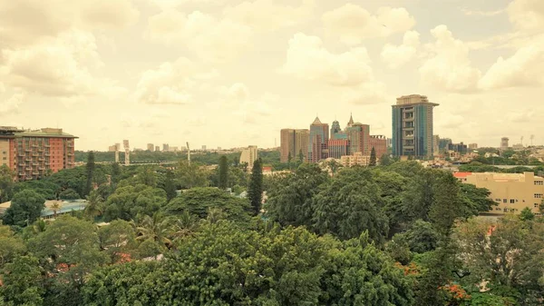 Bangalore,Karnataka,India-June 19 2022: View of Bangalore cityscape from terrace of Chancery Pavilion Hotel. Stadium and skyscrapers such as Prestige UB City Concorde Block visible through green cover.