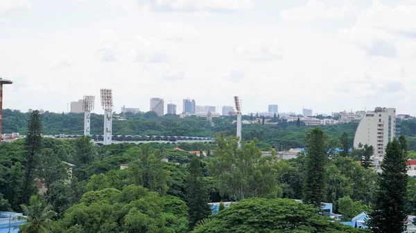 Bangalore,Karnataka,India-June 19 2022: View of Bangalore cityscape from terrace of Chancery Pavilion Hotel. Stadium and skyscrapers such as Prestige UB City Concorde Block visible through green cover.