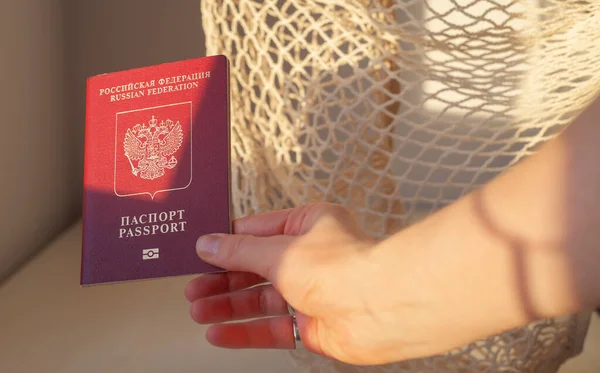 Russian passport in hand. Immigration to Russia concept. Hand holding out a document.