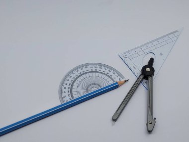 Beyaz zemin üzerinde Yüksek Açı Görünüm Geometri pusulası, cetvel ve kalem