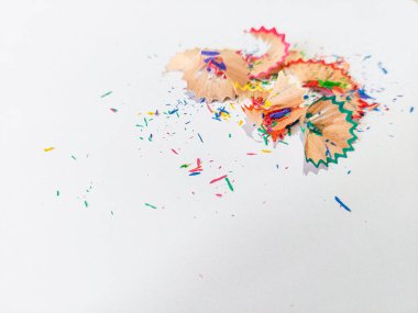 Wooden colored pencil sharpening shavings pile on white isolated background, top view, copy space, white space