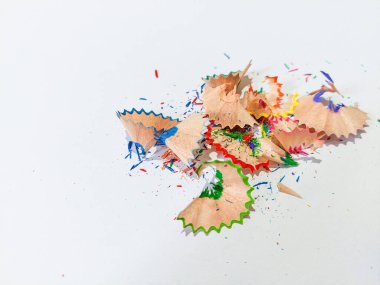 Wooden colored pencil sharpening shavings pile on white isolated background, top view, copy space, white space