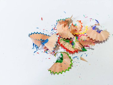 Wooden colored pencil sharpening shavings pile on white isolated background, top view, copy space, white space