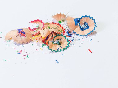 Wooden colored pencil sharpening shavings pile on white isolated background, top view, copy space, white space