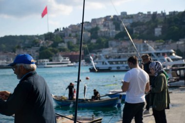 İstanbul, Türkiye - Haziran 2022: Taze tutulan uskumru balığı oltaya takıldı. Balıkçılar ve çevredeki insanlar.