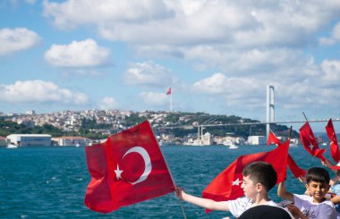 Çocuklar Türk bayrağı sallıyor. Bir grup çocuk bir gemide Türk bayrağı sallıyor