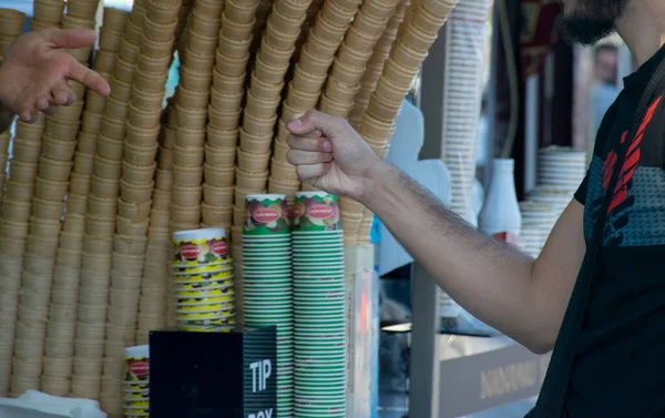 Turkish ice cream vendor jokes and customers having fun. Traditional turkish ice cream sales.